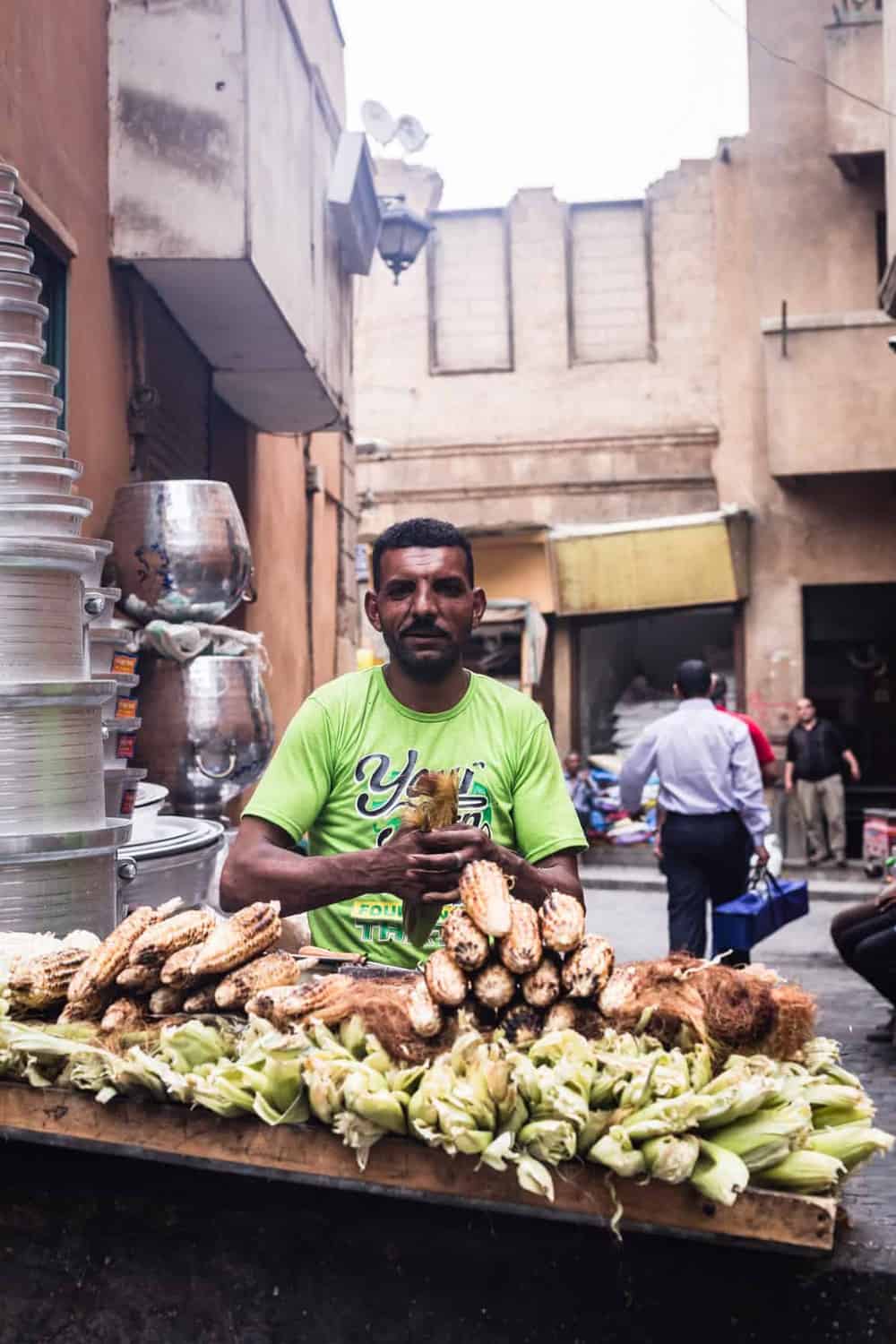 portrait shot of of a man grilling corn on the street in Old Cairo.