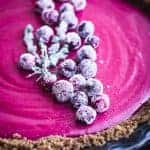 Cranberry Gingersnap Pie. Topped with sugared cranberries and sugared thyme. Side Ange shot. Up close. On a black background.