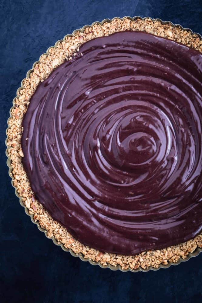 Chocolate ganache filling is poured into pretzel crust.