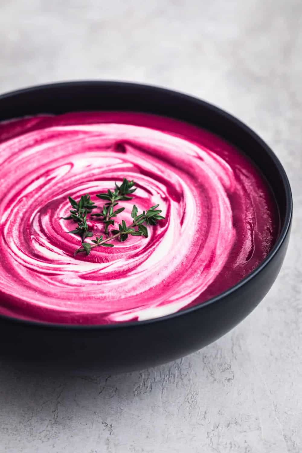 Roasted Beet Soup with Cashew Cream Swirl, side angle shot, white background.