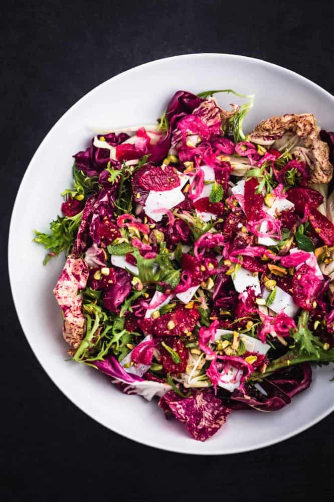 Blood Orange & Fennel Salad with chicories, pistachios, ricotta salata, and mint in a big white bowl.