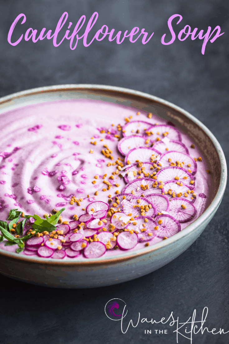 Roasted Purple Cauliflower Soup with Sliced Purple and Pink Radishes, tiny basil leaves, Bee Pollen and Flaky Sea Salt. Side angle shot, left side cut off, on a dark grey white/light blue background.