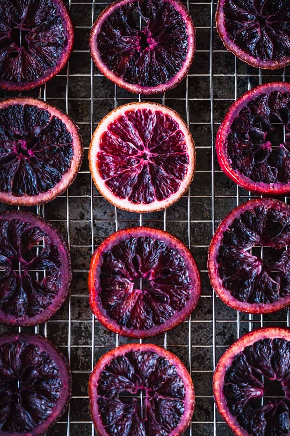 Blood Oranges have been candied and are drying on a cooling rack with a pan underneath to catch any excess drippings.
