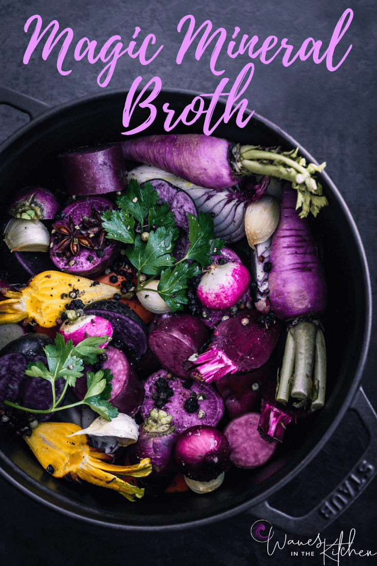In process shot of a cast iron pot with beets, radishes, potatoes, parsley, onions, garlic and peppercorns all read to pour water on top and make Magic Mineral Broth.