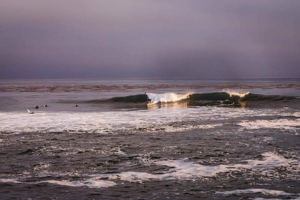 A surfer taking off on a wave in Santa Cruz