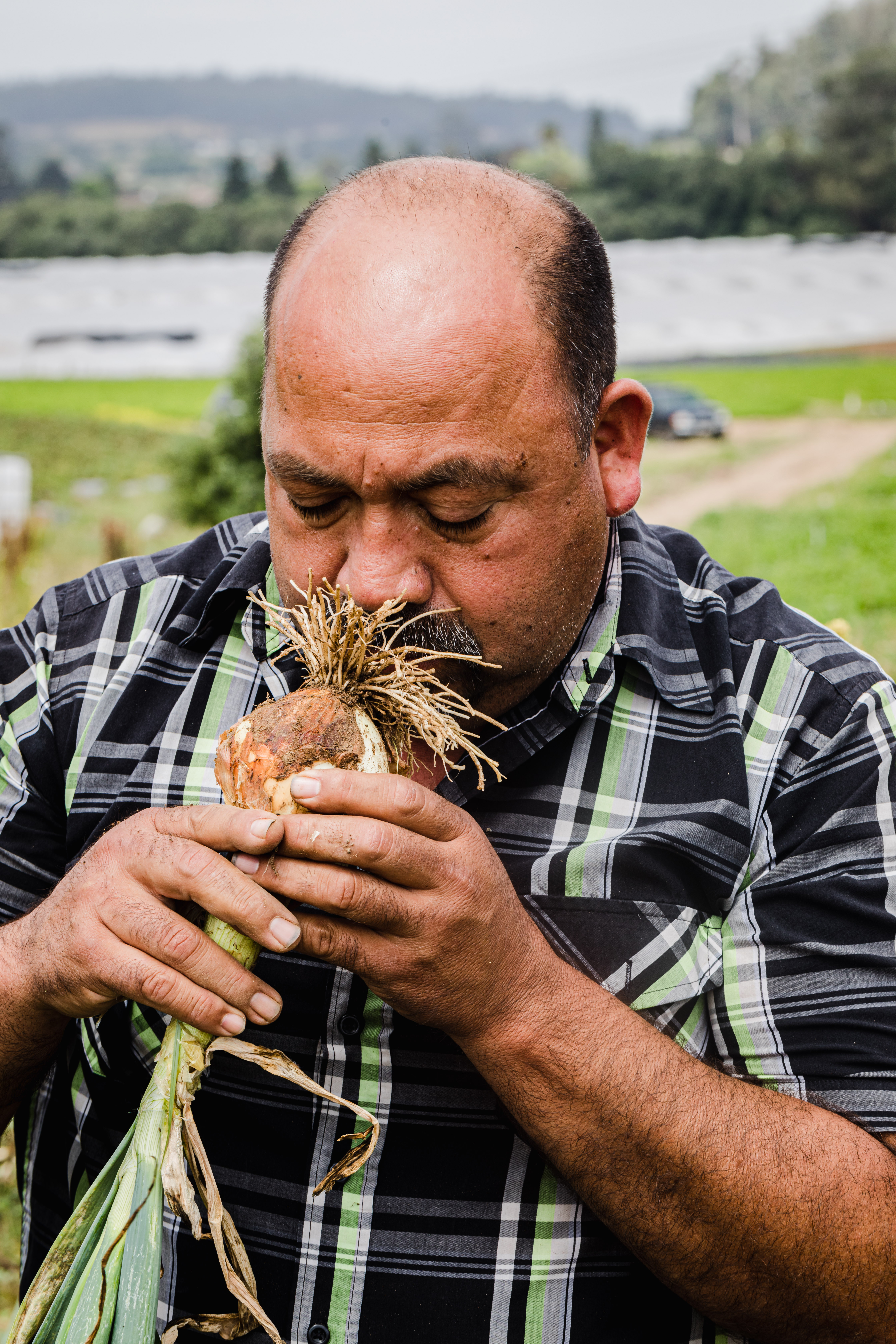JSM Organics founder, Javier Zamora, smelling an onion.