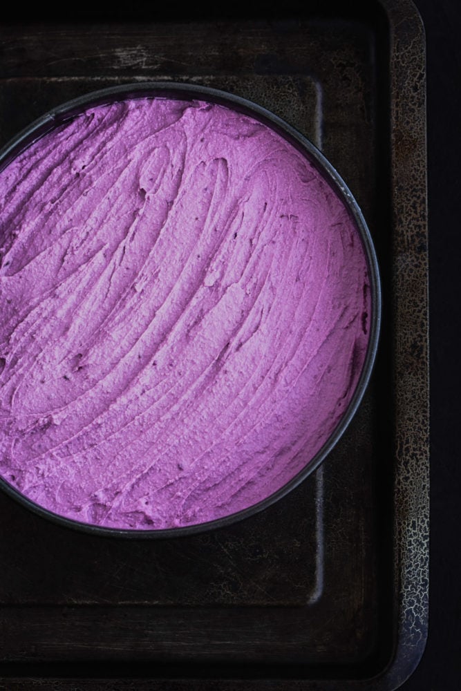 Purple sweet potato cheesecake batter, spread out on a spring foam pan.