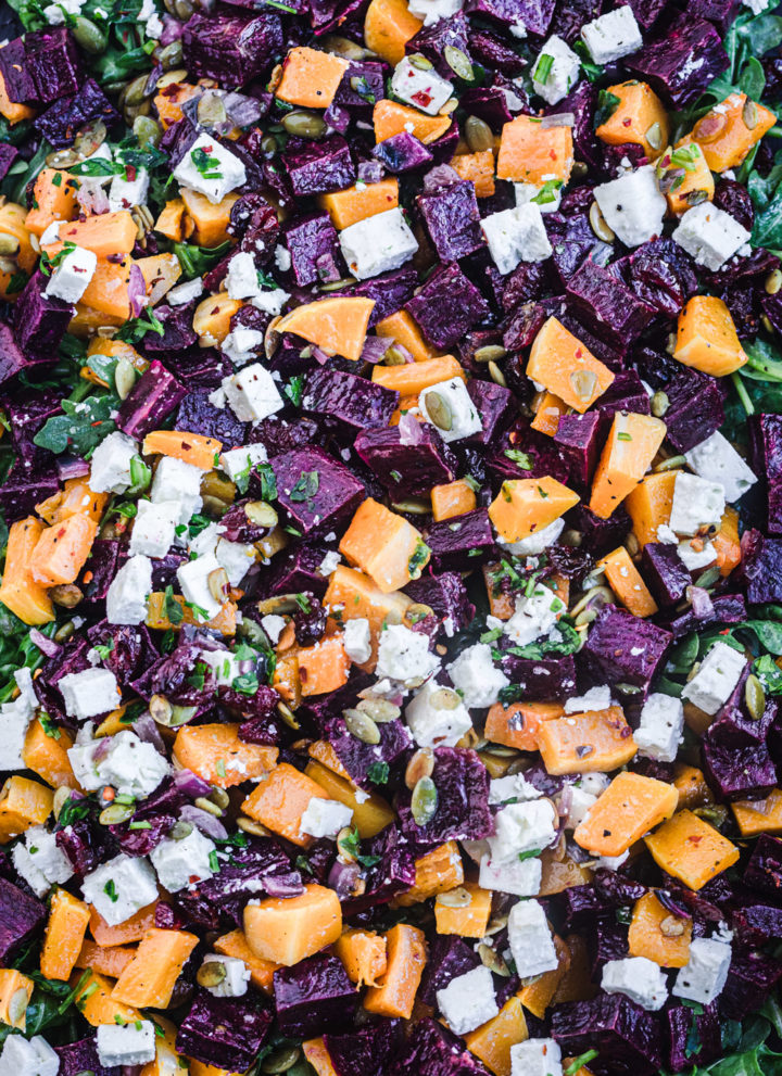 Sweet potato salad with argulula, feta, dried cranberries, red onions, pepitas, parsley and a maple-lime vinaigrette, overhead shot.