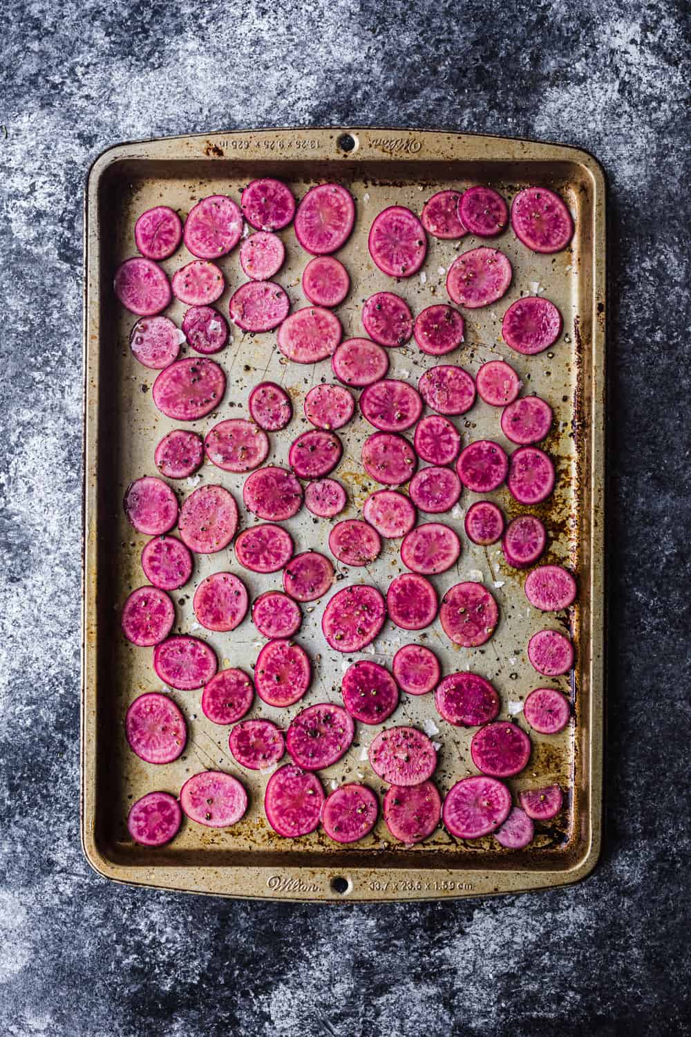 baking sheet with pink potatoes thinly sliced, overhear shot to be used in the farmers market salad