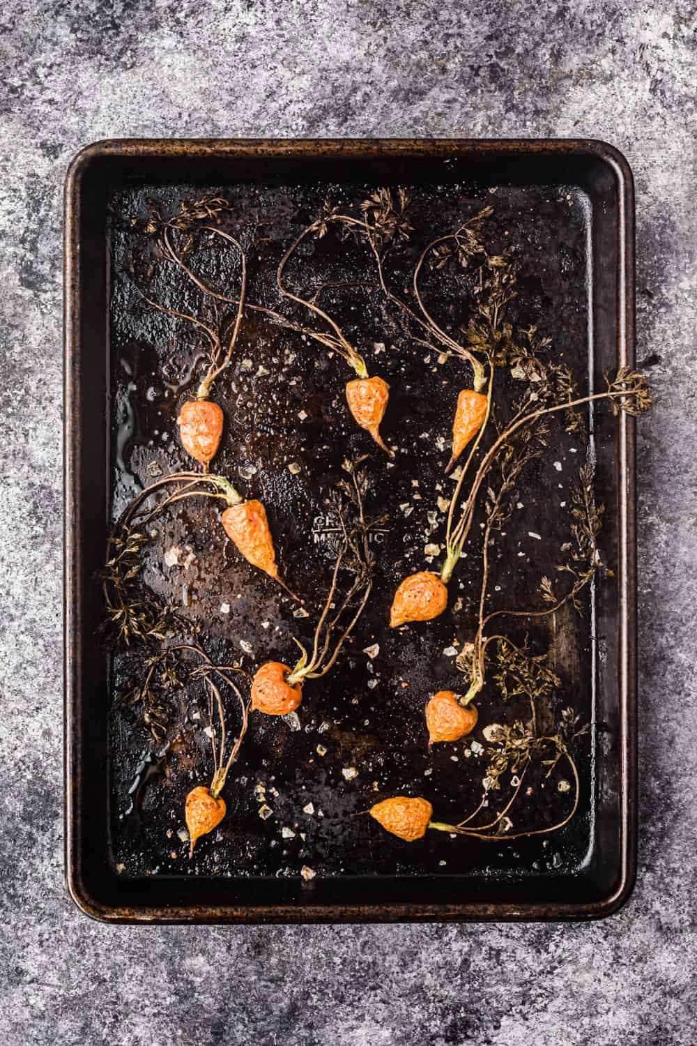 baking tray with roasted baby carrots, flaky sea salt and pepper to be used in the farmers market salad