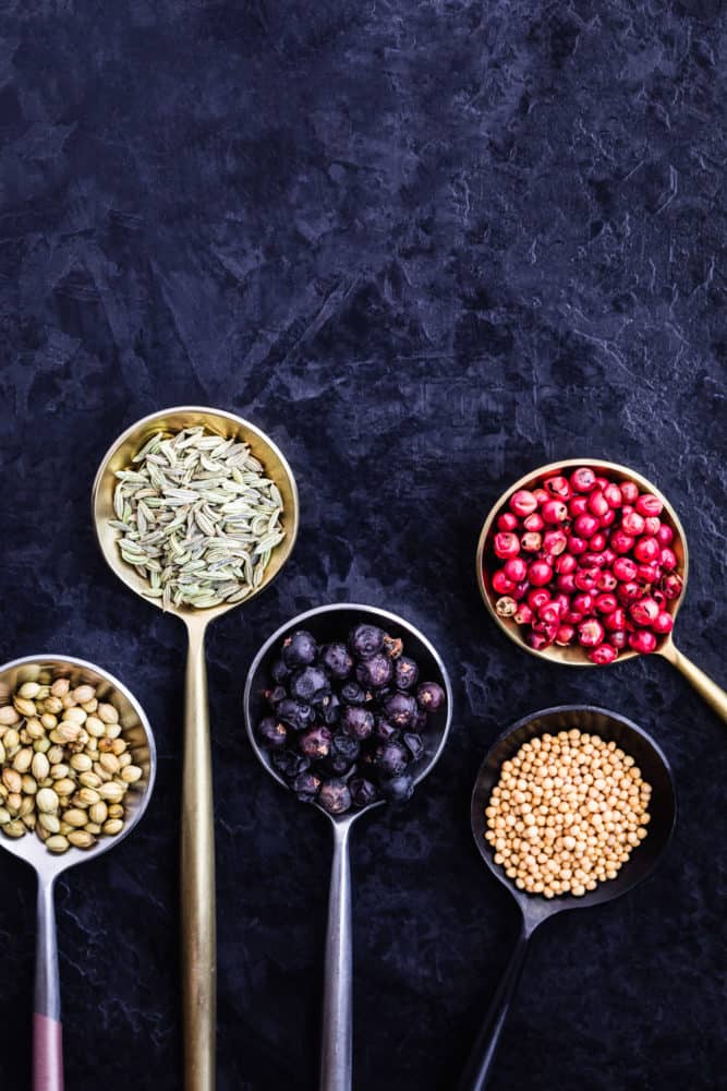ingredient shot of 5 spices in spoons on a black background