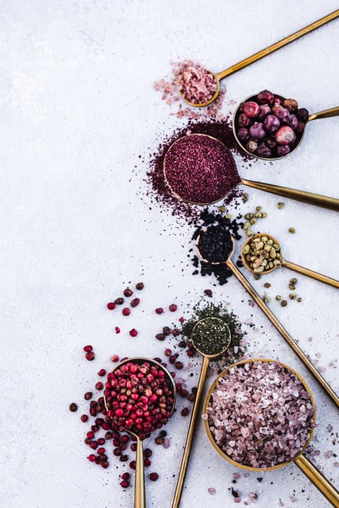 ingredient shot of spices and salts in spoons on a white background