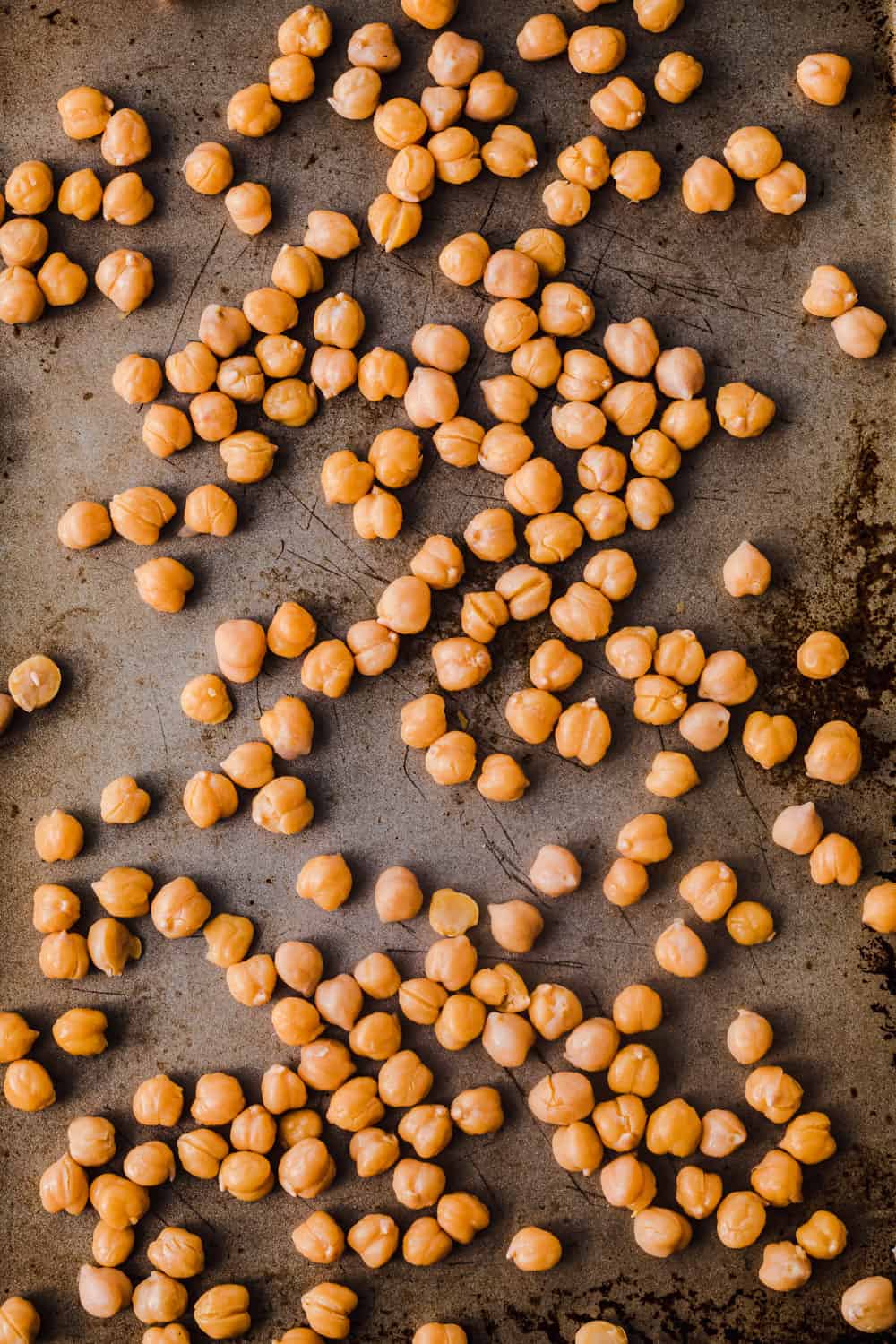 chickpeas with their skins taken off, on a sheet pan, overhead shot
