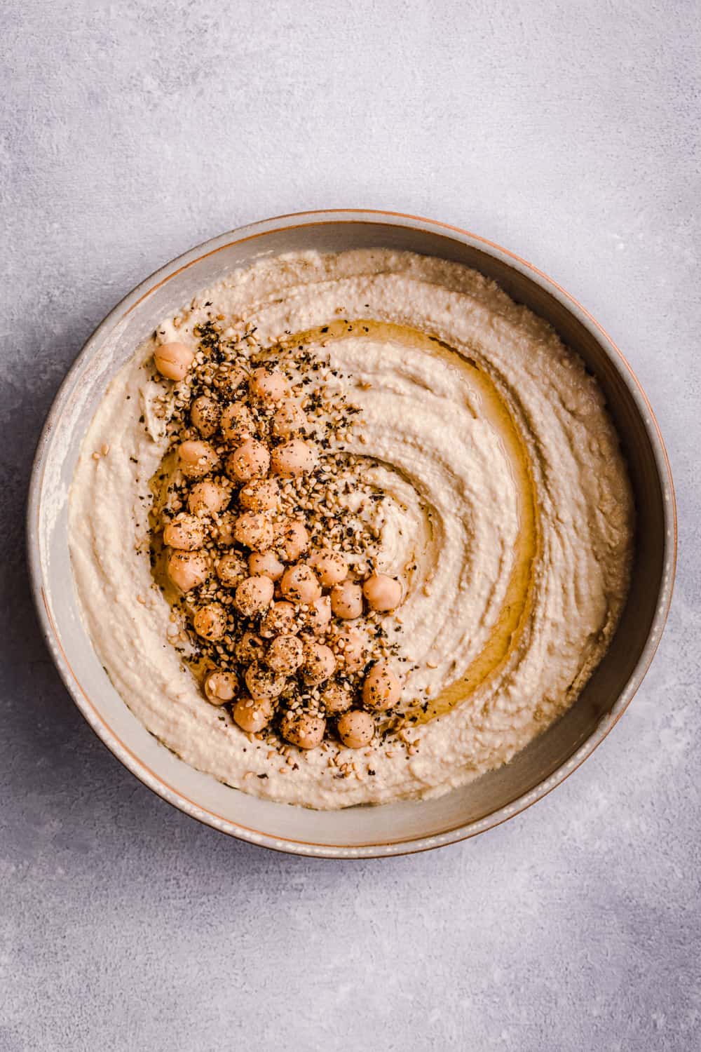 overhead shot of hummus in a bowl with seeds and other toppings, overhead shot