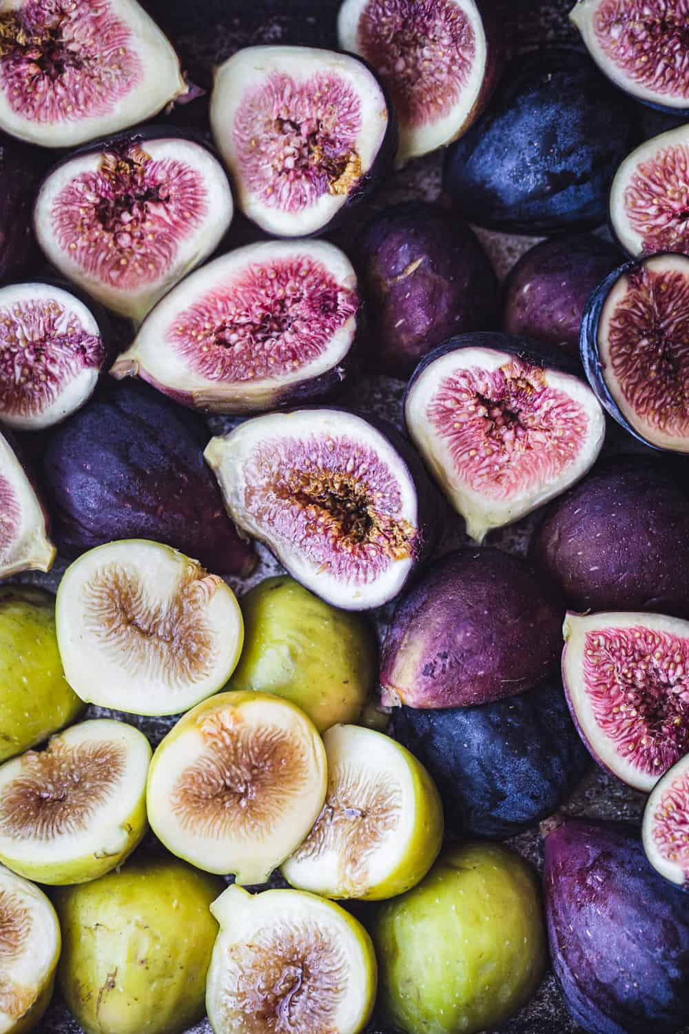 Fresh raw figs, purple and green, cut in half; overhead shot.