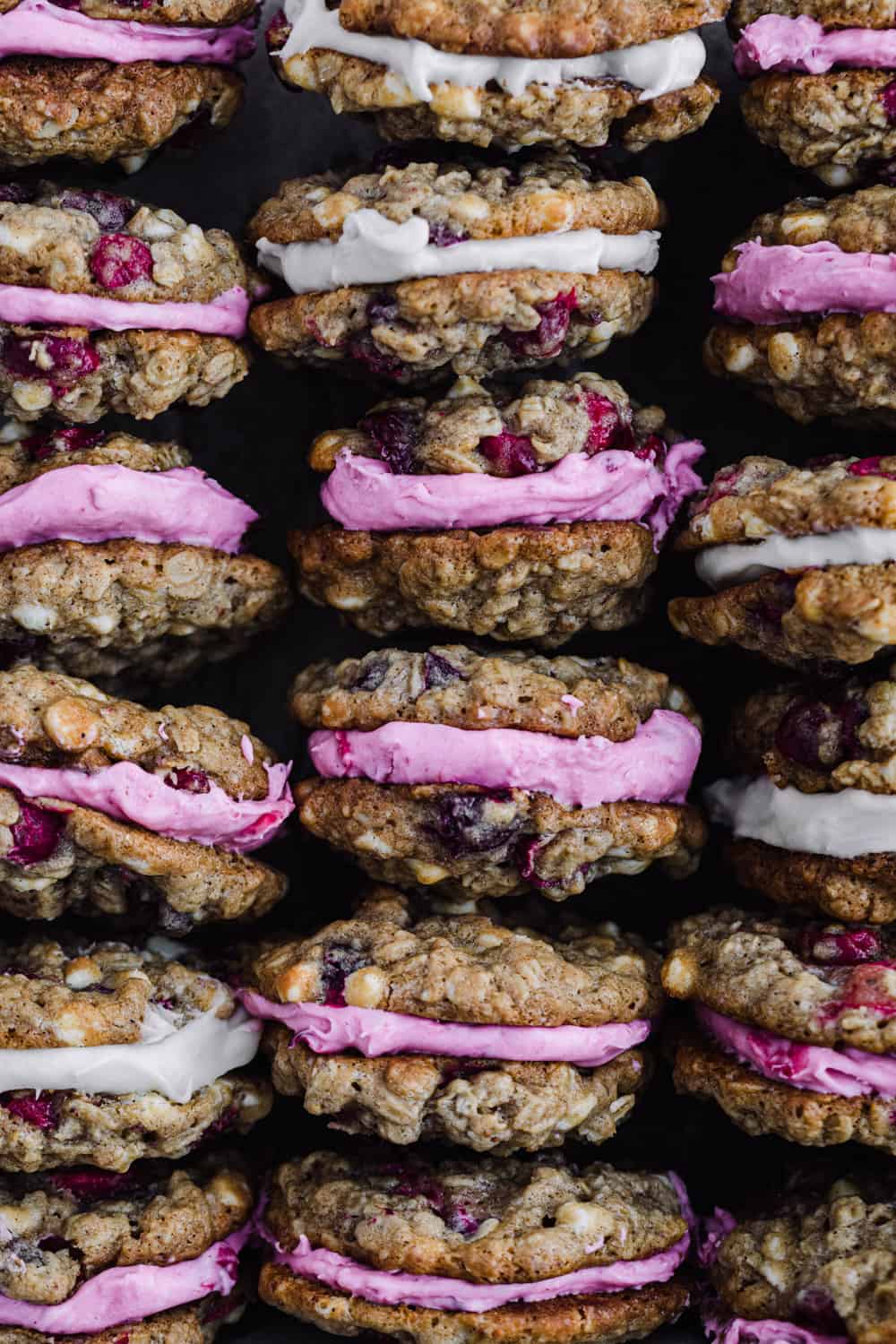 Cranberry White Chocolate Oatmeal Cookies, stuffed with either cranberry cream cheese or vanilla mascarpone, overhead shot; cookies stacked vertically so filling can be seen.