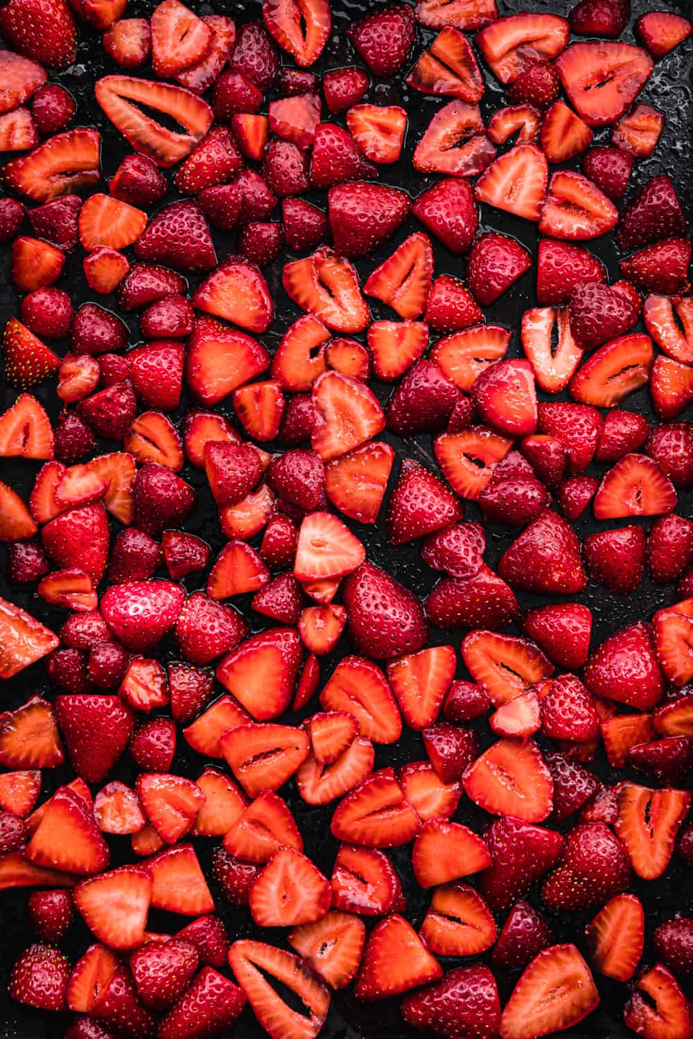 sliced strawberries on a baking sheet; overhead shot.