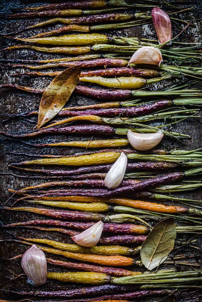 Roasted rainbow carrots with garlic and bay leaves; overhead shot