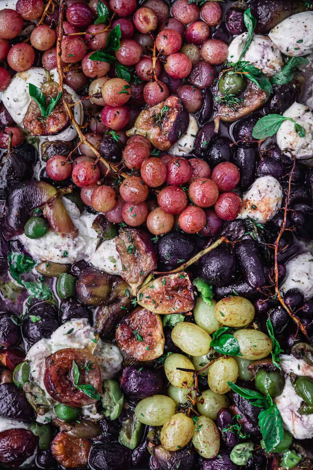 Balsamic & thyme roast grapes topped with burrata read to be eating; still on a baking sheet and overhead shot
