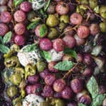 Roast Roasted grapes topped with burrata, olives and fresh herbs; overhead shot