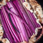 Rhubarb Galette with a whole vanilla bean straight out of the oven, in a tart pan and overhead shot.