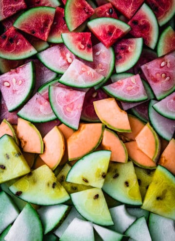 red, pink, orange, yellow and white melon chunks arranged by color