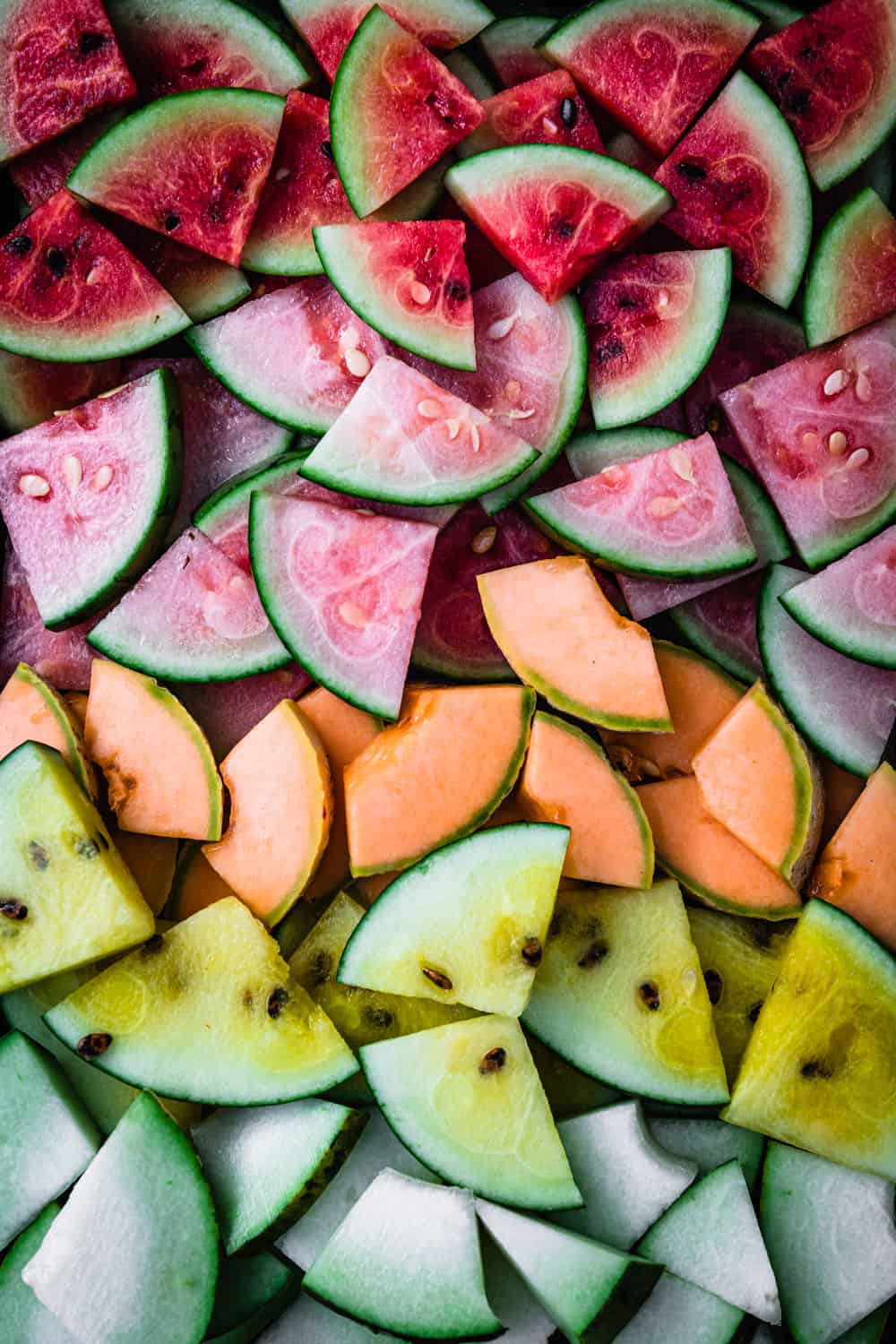 red, pink, orange, yellow and white melon chunks arranged by color