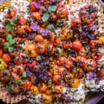 Pasta with Burrata on a plate with colorful cherry tomatoes, basil and olive oil.