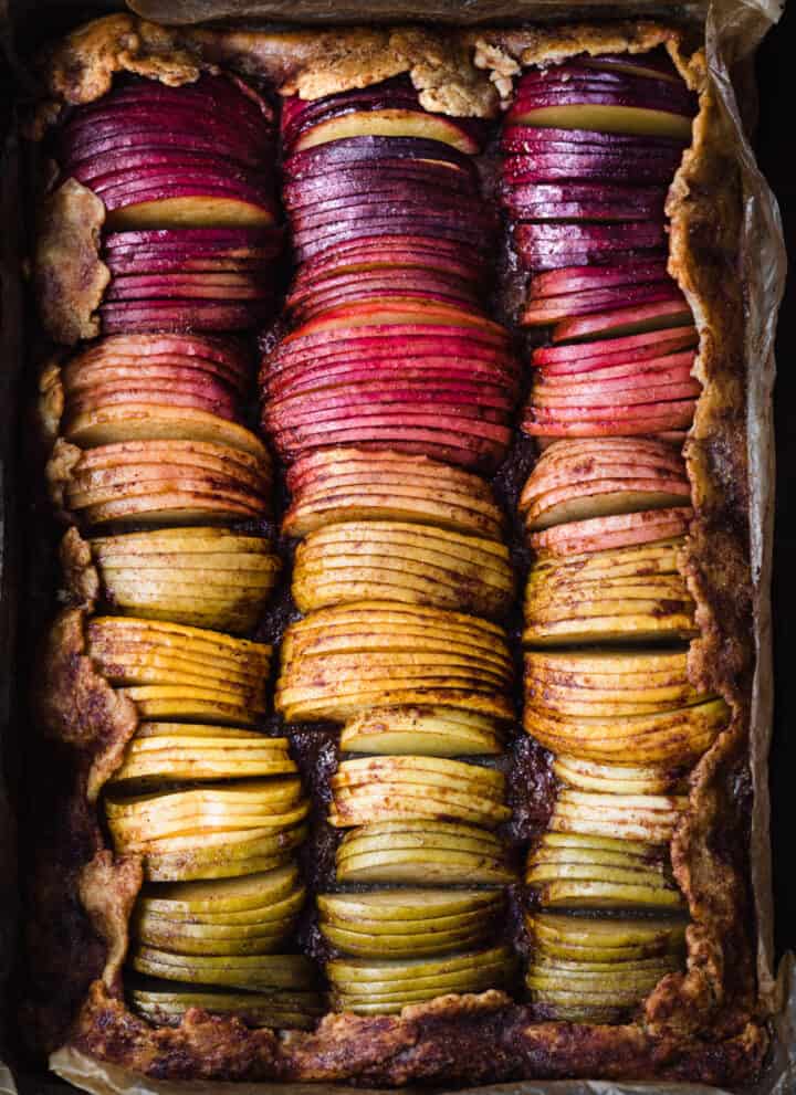 Spiced rainbow apple galette with purple, red, pink, orange and green apple slices.