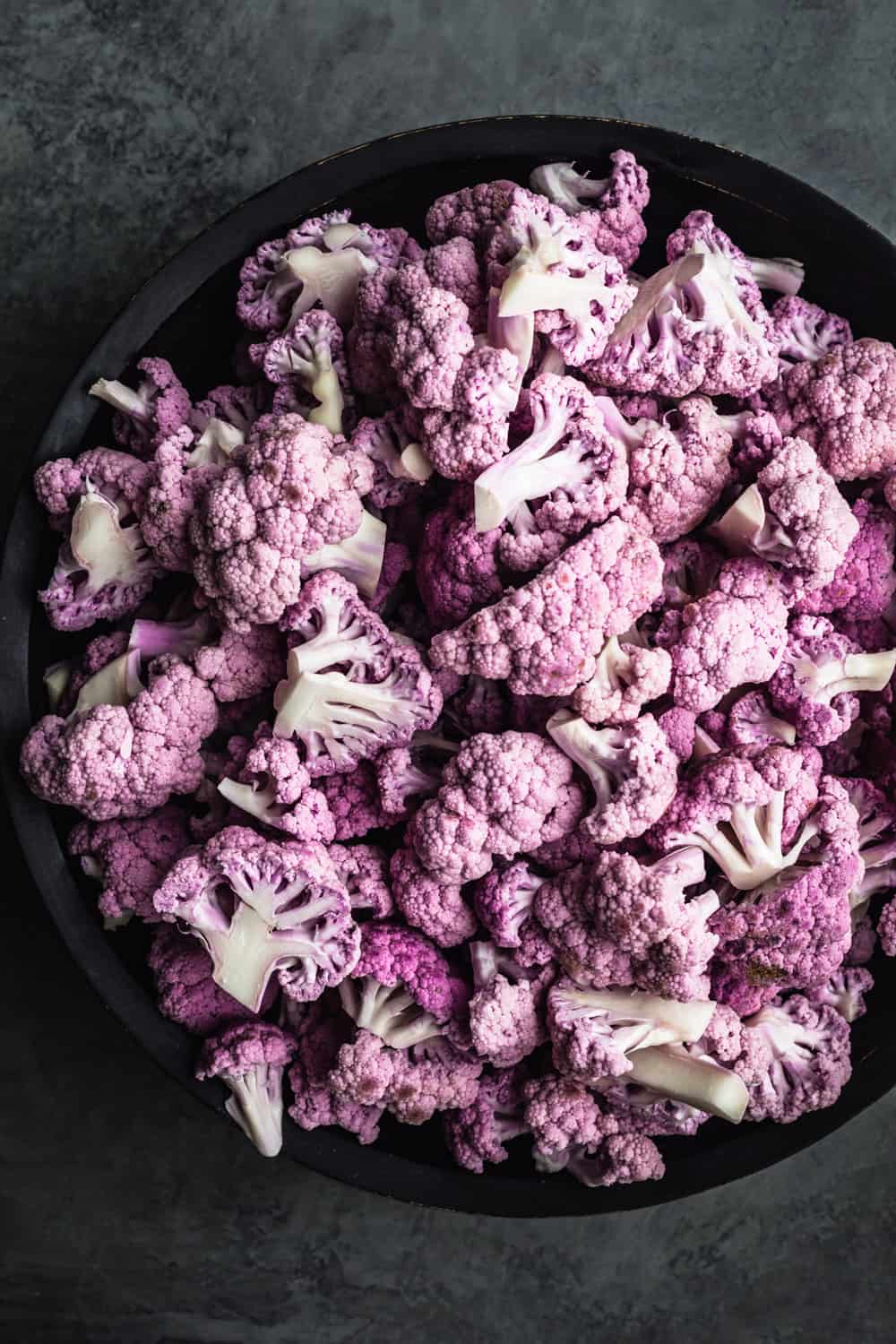purple cauliflower florets in black bowl