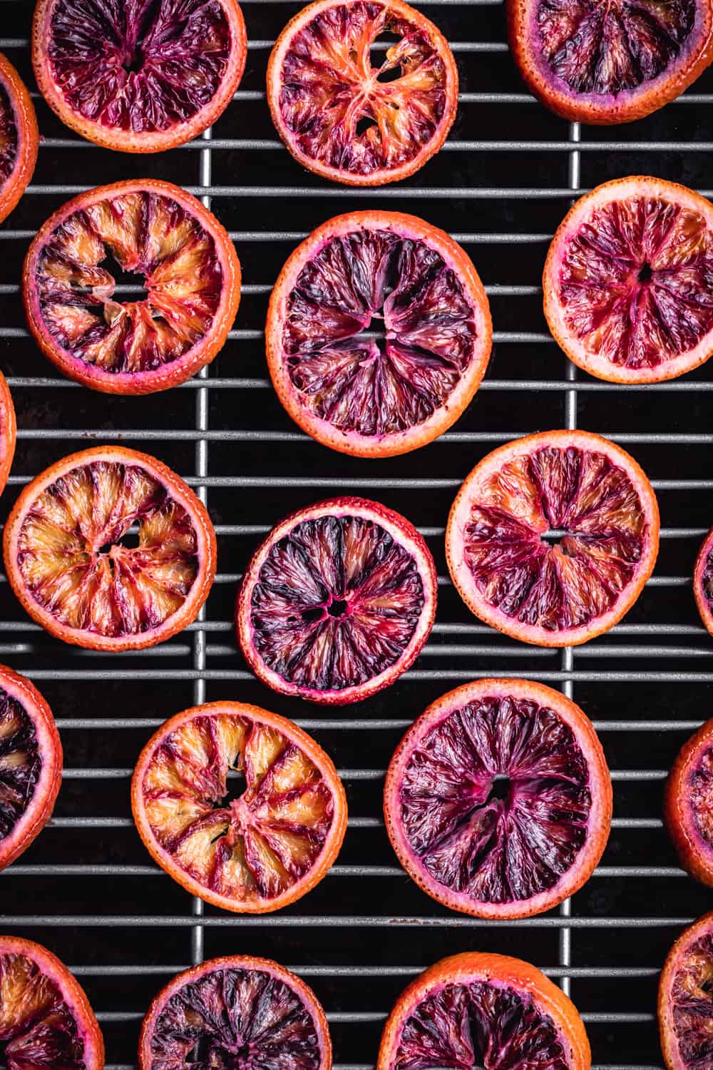 blood orange slices drying on a wire rack on top of a baking sheet