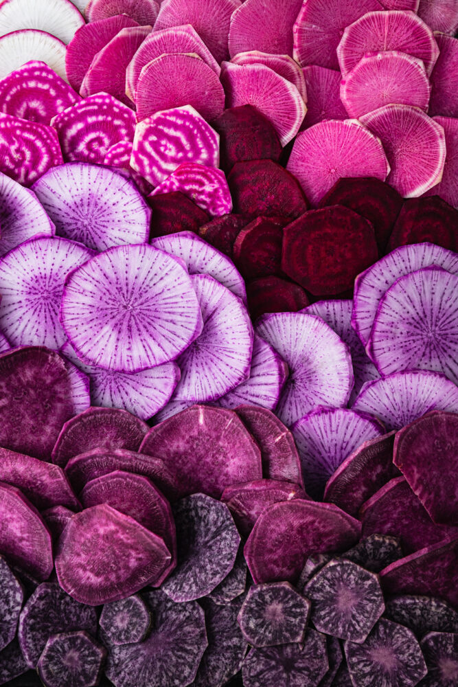Purple potatoes, purple sweet potatoes, purple radishes, pink radishes, and red beet slices.