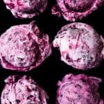 Six scoops of purple blackberry cheesecake ice cream with blackberry swirls, overhead close-up on a black background